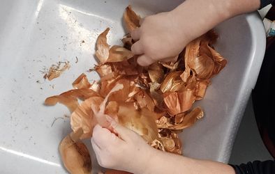Otrok pripravlja čebulne olupke